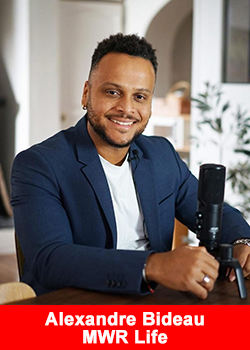 Alexandre Bideau, MWR Life leader, seated at a desk with a microphone, smiling confidently in a navy blazer.