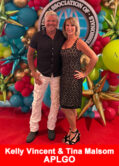 Kelly Vincent and Tina Malsom, top leaders at APLGO, standing together at an industry event with a colorful balloon display backdrop.